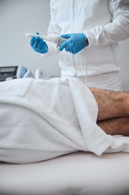 Hombre siendo tratado en una clínica moderna con máquina BTL