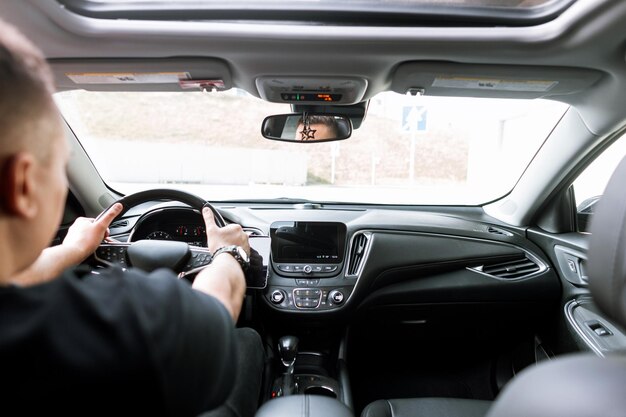 Foto hombre se sienta en un coche y está listo para ir a comprar y alquilar un coche conductor