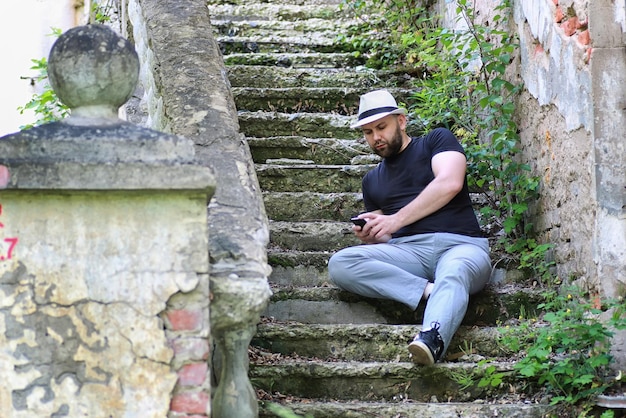 El hombre se sienta en la escalera abandonada