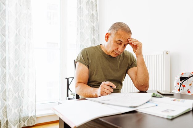 Un hombre se sienta en un escritorio y mira un documento con la palabra seguro.