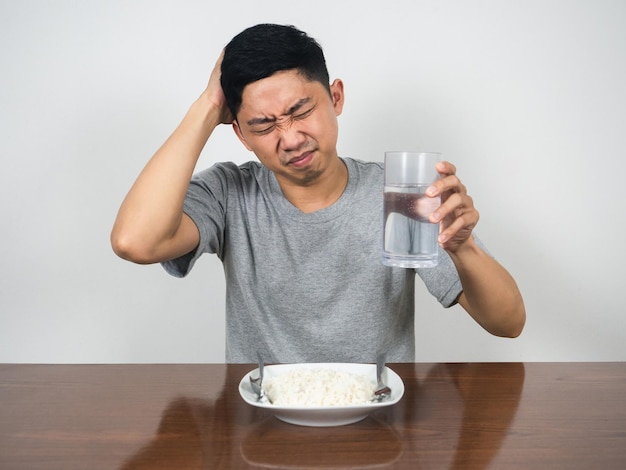 El hombre siente dolor de cabeza y la enfermedad no quiere comer en la mesa