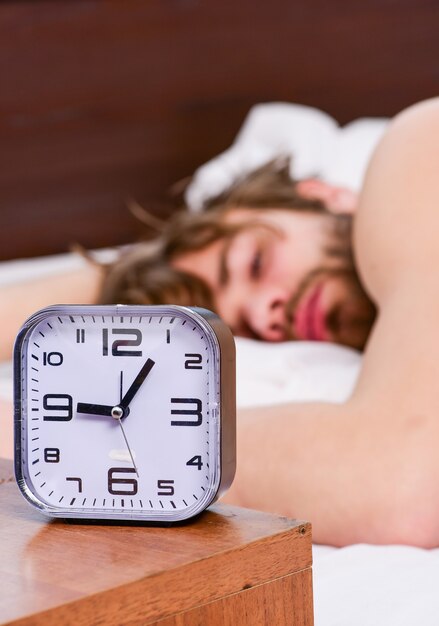 Hombre siente dolor de espalda en la cama después de dormir Estirar después de despertarse por la mañana Retrato