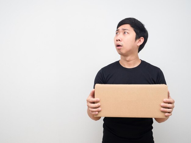 El hombre se siente sorprendido y sostiene la caja en la mano y mira el espacio de la copia