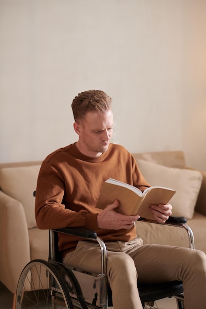 Hombre en silla de ruedas leyendo libro cautivador