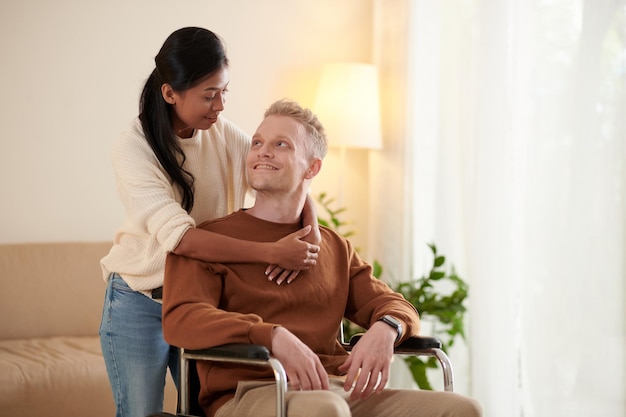 Hombre en silla de ruedas y su novia cariñosa