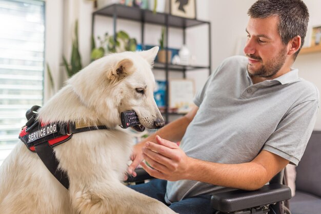 Foto hombre en silla de ruedas con su perro de servicio