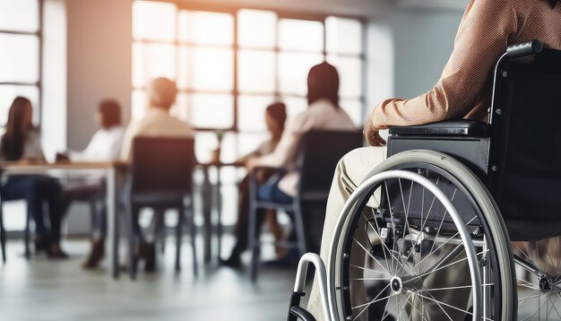 Hombre en silla de ruedas en el trabajo en la oficina trabajando en compañía con personas