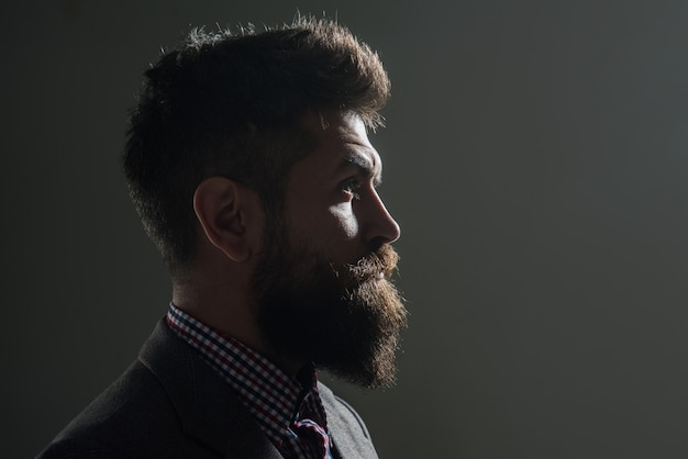 Hombre silueta con barba y bigote en estilo vintage. Retrato de perfil hipster. Silueta de hombre barbudo serio, mirando hacia adelante. Retrato de vista lateral. Copie el espacio para su publicidad.