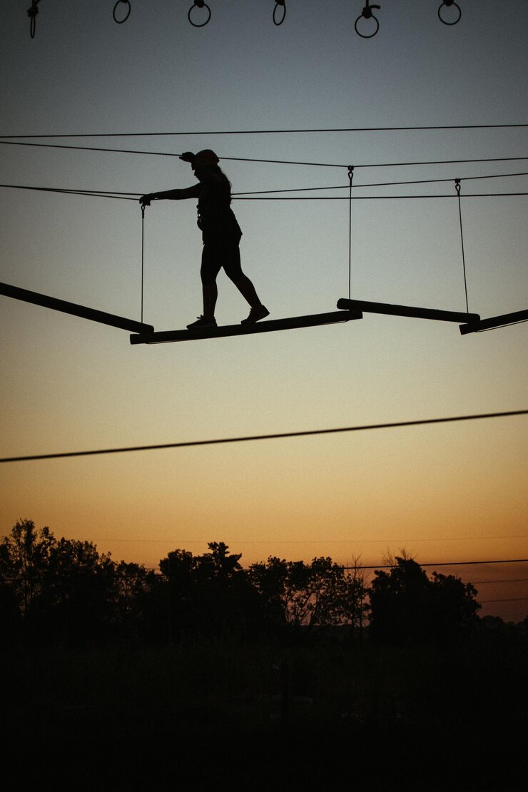 Foto hombre silueta con los brazos levantados contra el cielo durante la puesta de sol