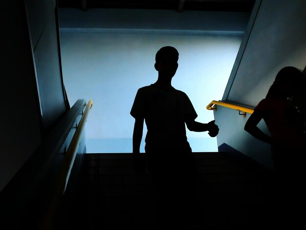 Foto hombre silueta caminando por las escaleras en el metro