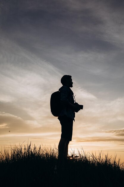 Hombre en silueta disfrutando de una increíble puesta de sol durante el rodaje