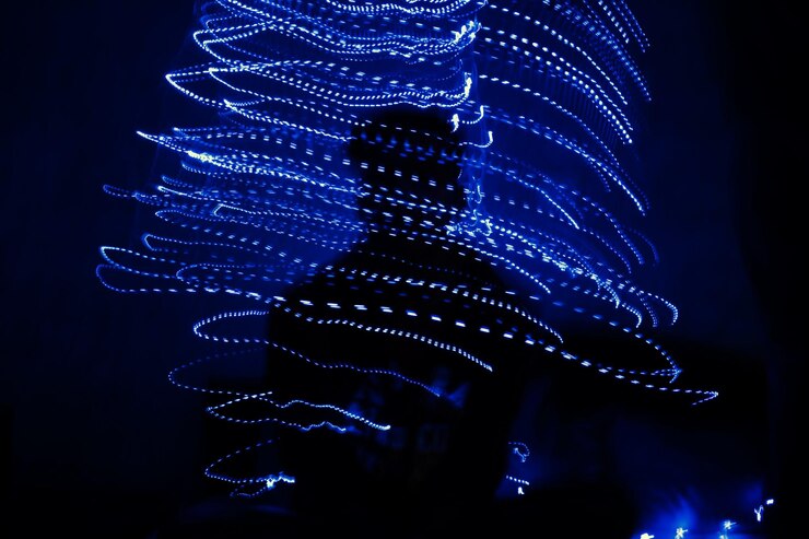 Foto hombre silueta con luces navideñas iluminadas por la noche