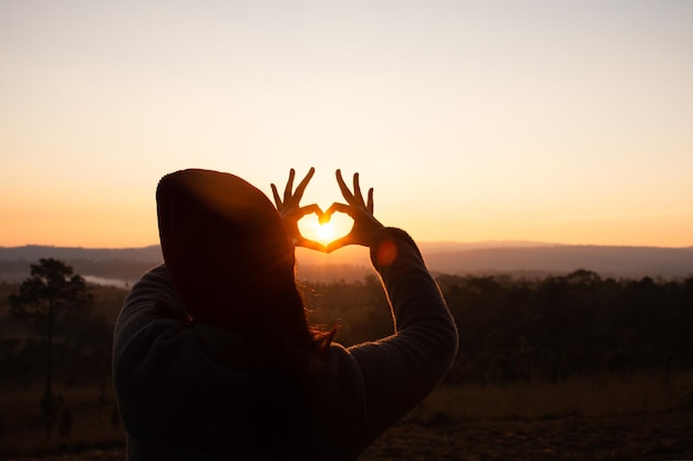 Foto hombre silueta a la luz del sol contra el cielo durante el amanecer