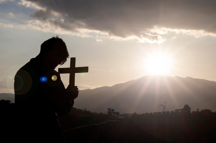 Foto hombre silueta de pie en un camino de montaña contra el cielo durante la puesta de sol