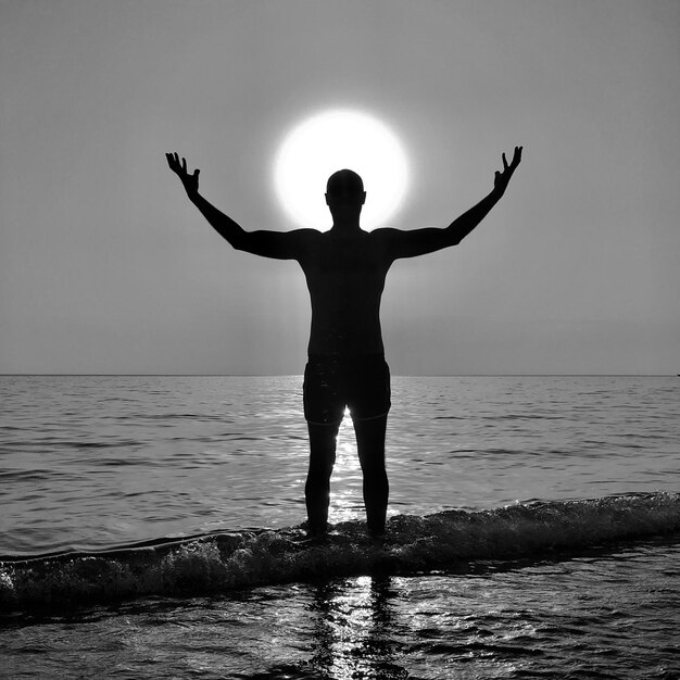 Foto hombre silueta de pie en el mar contra el cielo despejado