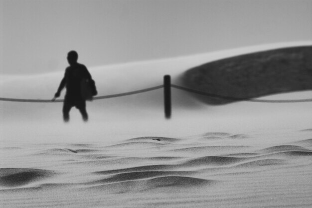 Foto hombre silueta en la playa contra el cielo despejado