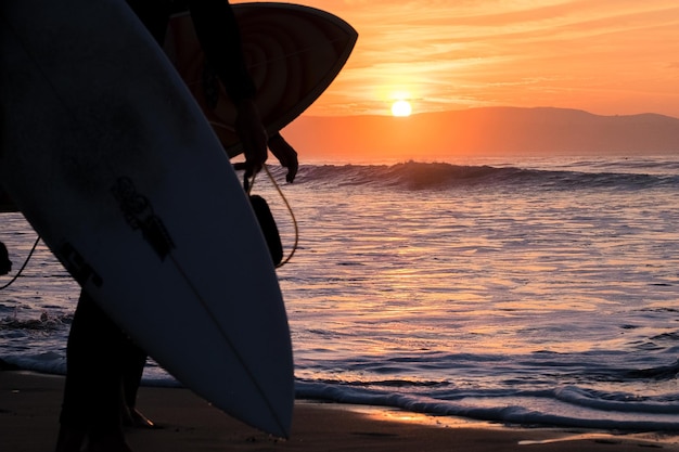 Hombre silueta en la playa durante la puesta de sol