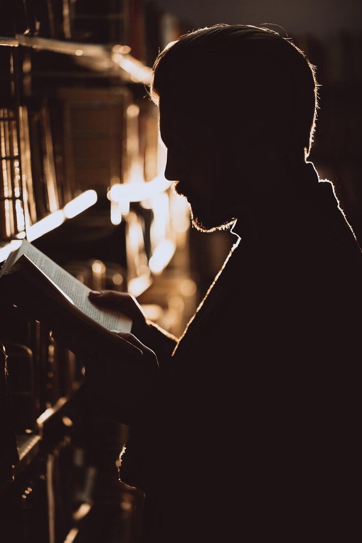 hombre, en, silueta, posición, entre, estantes, en, biblioteca