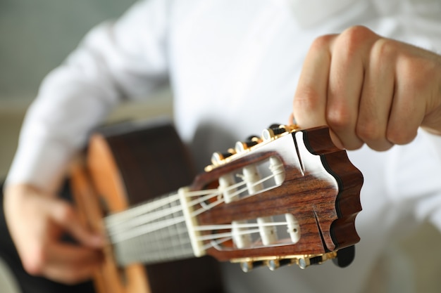 El hombre sintoniza la guitarra clásica