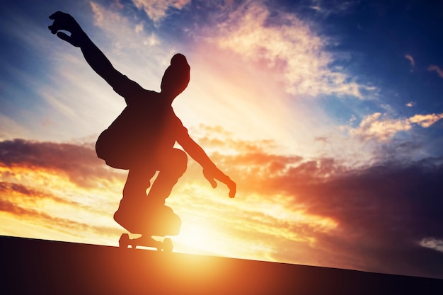 Hombre skateboarding al atardecer.