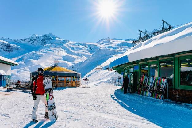Hombre con snowboard en la estación de esquí Hintertux Glacier en Zillertal en Tirol en Austria en invierno en los Alpes. Snowboarder en las montañas alpinas con nieve. Diversión cuesta abajo. Vacaciones familiares. Laderas blancas.
