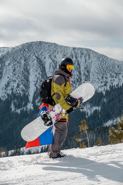 Hombre snowboarder con bandera de eslovaquia en la pendiente de la estación de esquí