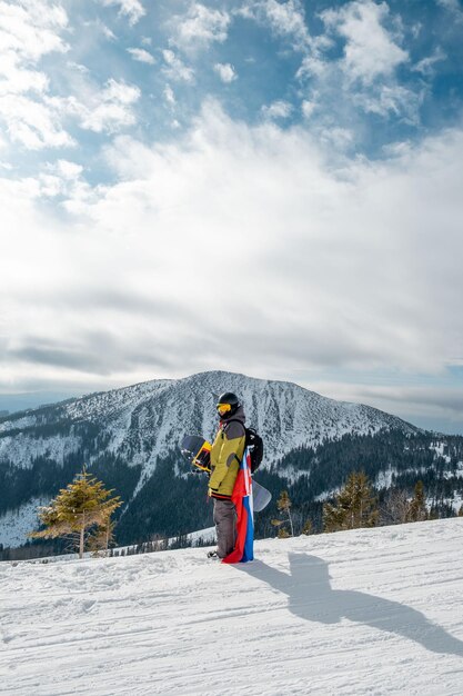 Hombre snowboarder con bandera de eslovaquia en la pendiente de la estación de esquí