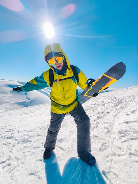 Hombre snowboarder en la cima de las montañas hermosa vista al fondo