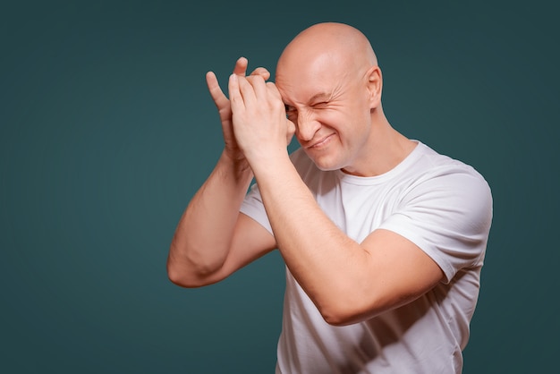 Un hombre sobre un fondo azul en la mano cerca de sus ojos como un telescopio Peeps