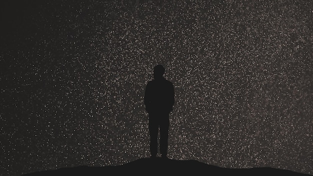 El hombre se para sobre un fondo de cielo estrellado.