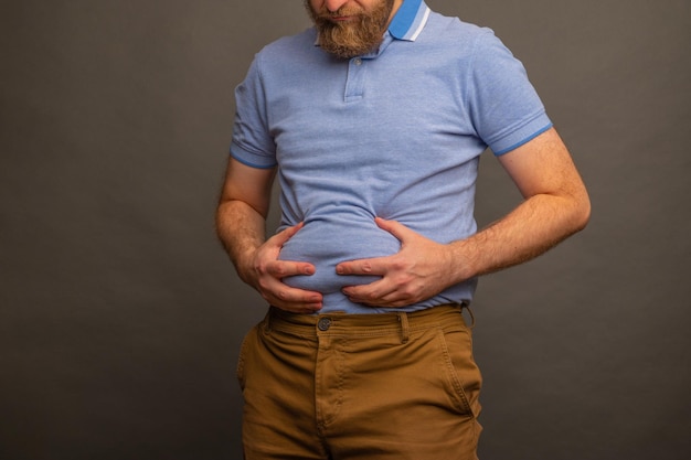 Hombre con sobrepeso en camiseta sobre fondo gris primer plano Espacio para texto