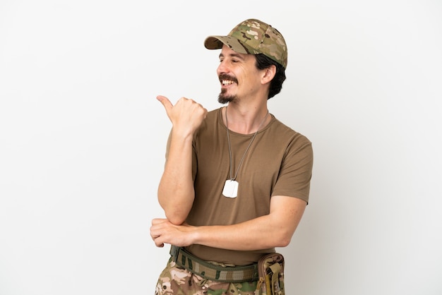 Hombre soldado aislado sobre fondo blanco apuntando hacia el lado para presentar un producto