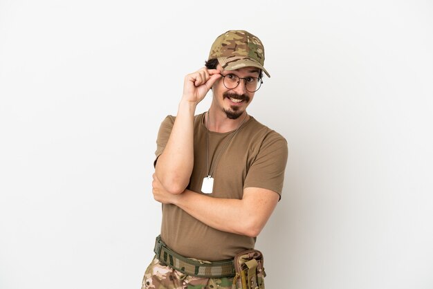 Hombre soldado aislado sobre fondo blanco con gafas y feliz