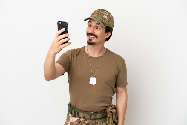 Hombre soldado aislado sobre fondo blanco haciendo un selfie