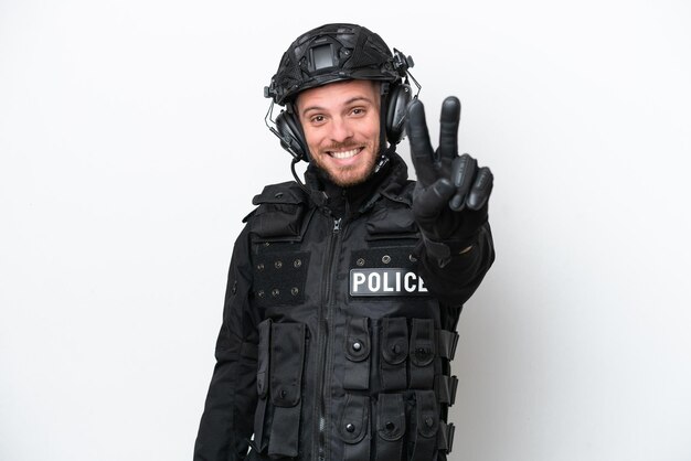 Hombre soldado brasileño aislado sobre fondo blanco sonriendo y mostrando el signo de la victoria