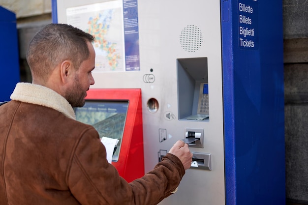 hombre solo comprando un billete de tren