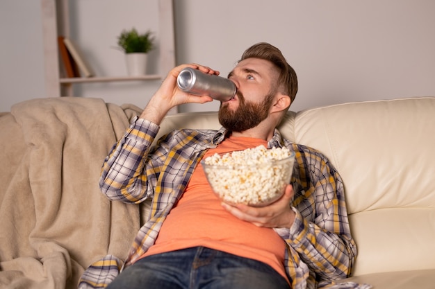 Hombre soltero en el sofá viendo la televisión