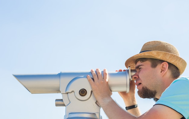 Hombre del sombrero mirando telescopio