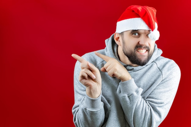 Un hombre con un sombrero de Navidad de Santa Claus tiene juguetes de Navidad, bolas de oro en su mano