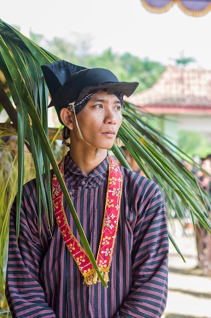 Un hombre con un sombrero negro con una borla roja y dorada.