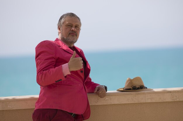 hombre con sombrero de paja y chaqueta rosa