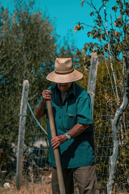 Foto hombre con sombrero de pie junto a las plantas