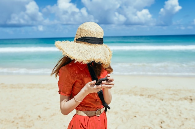 Foto hombre con sombrero de pie en la playa contra el mar