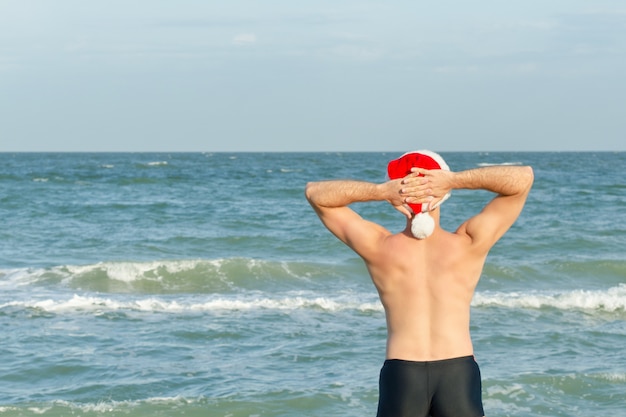 Hombre; en el sombrero de Santa se encuentra a la orilla del mar