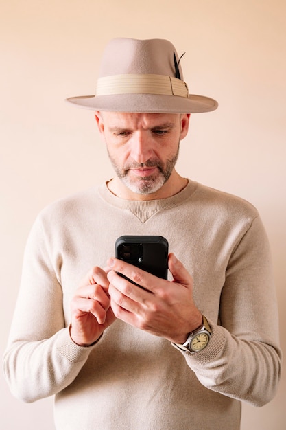 Hombre con sombrero con teléfono inteligente en el interior