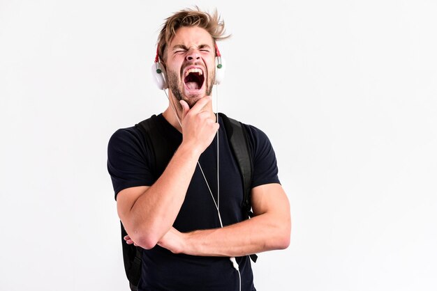 Hombre soñoliento Disfrutando de la música nueva tecnología en la vida moderna hombre musculoso sexy escuchar música hombre escuchar nueva canción aislado en blanco hombre sin afeitar en tecnología de diente azul auriculares concepto de vida moderno