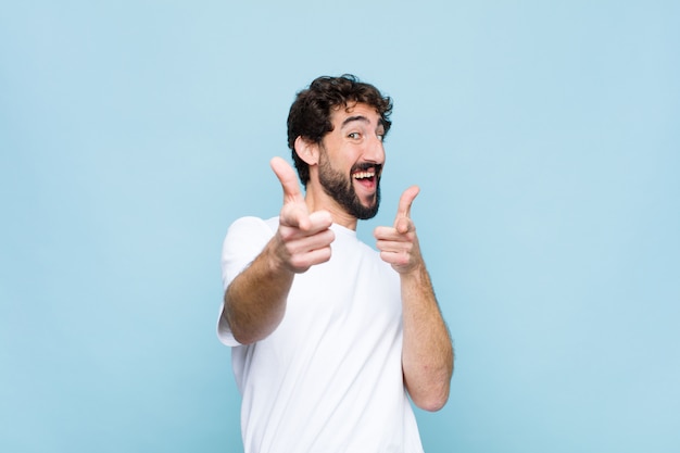 Hombre sonriendo con una actitud positiva, exitosa y feliz apuntando, haciendo firmar con las manos