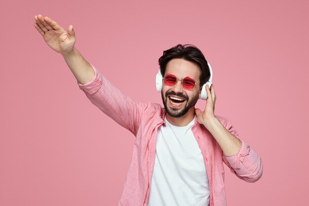 Hombre sonriendo y divirtiéndose mientras escucha música en auriculares