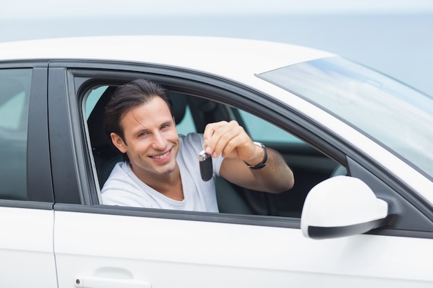 Foto hombre sonriendo y mostrando llave