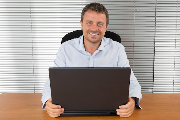 Hombre sonriendo en su escritorio en la oficina